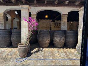 Historischer Innenhof mit Holzfässern und blühenden Blumen Fassreparaturwerkstatt