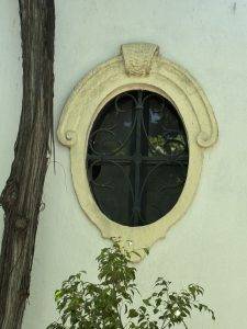 Ovales Fenster mit Gitter und Pflanze Überall gibt es schöne Details