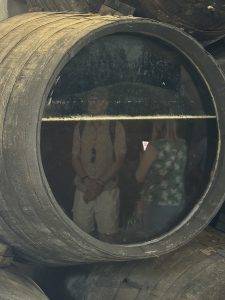 Holzfass mit Glasfenster und zwei Personen im Inneren Blick ins Fass - die weiße Linie ist Hefe auf dem Wein