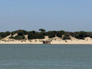 Küstenlandschaft mit Strand und kleinem Gebäude Versunkener Bunker