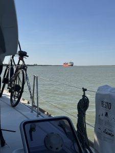 Fahrrad auf Bootsdeck vor rotem Frachtschiff Schiffverkehr direkt neben unserem Ankerplatz