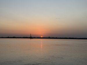 Sonnenuntergang am Fluss mit Vogelschwarm Sonnenuntergang über dem Río Guadalquivir