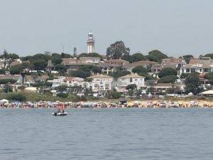 Strandpanorama mit bunten Sonnenschirmen und Leuchtturm Kein Platz mehr frei am Strand von Mazagon