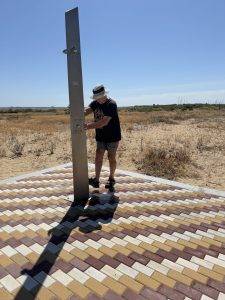 Person neben Wasserquelle in trockener Landschaft Erstmal Sand abspülen
