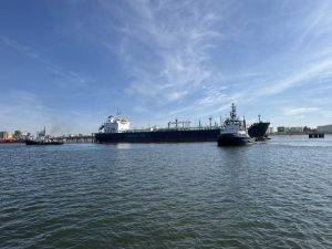 Frachtschiff im Hafen begleitet von Schlepper Ablegen mit Schlepperhilfe