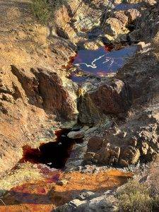 Rotes Wasser mit schwefelgelben Schlieren